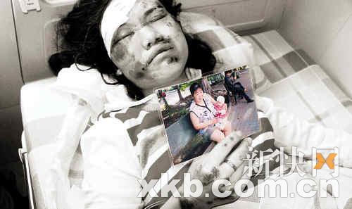 黎女士躺在病床上仍不时拿出照片呼唤儿子的名字。 